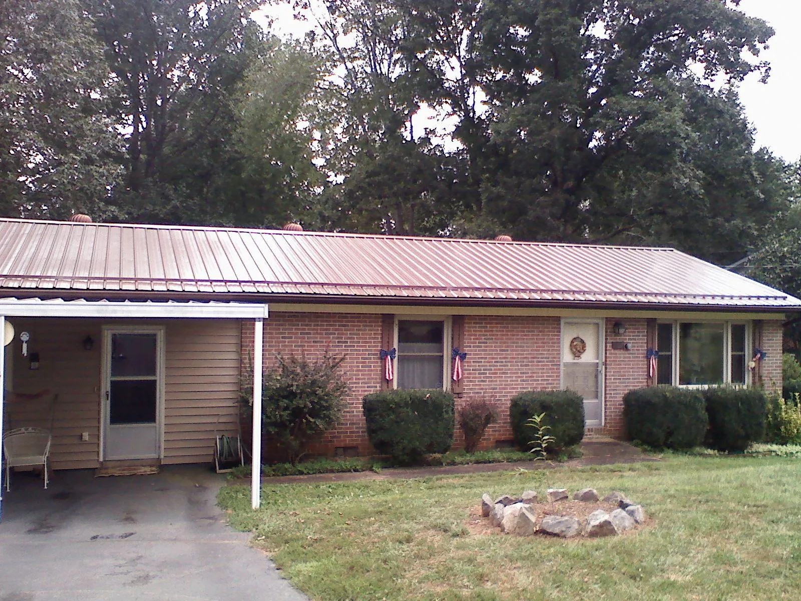 Bronze metal roof and carport on a brick ranch home — Roof Repair work by our crew in Gill